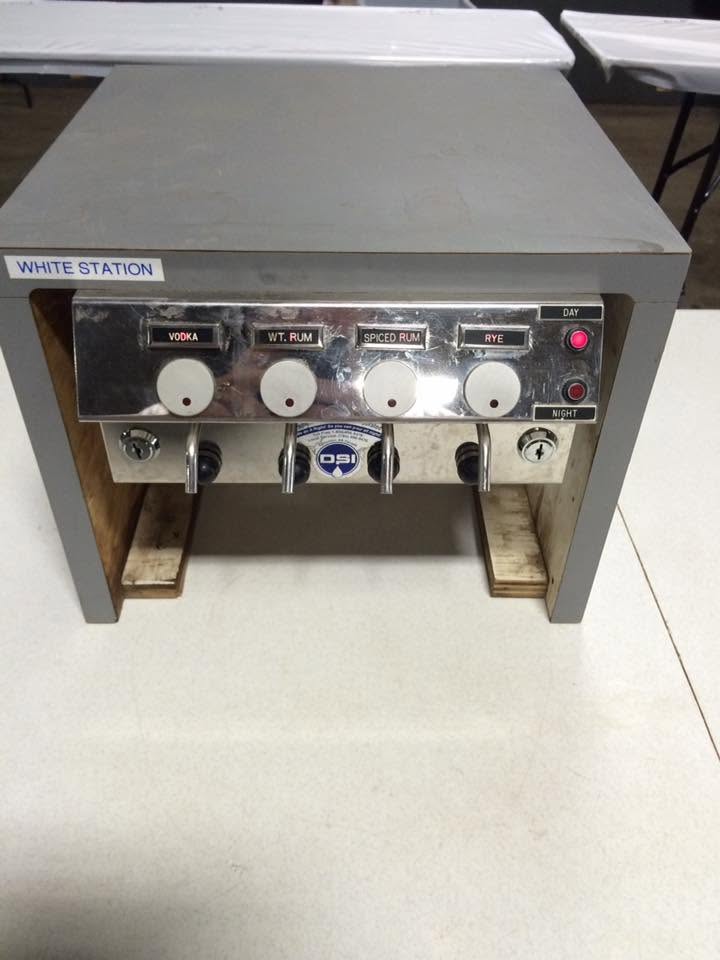 Portable liquor dispensing station labeled White Station with vodka, rum, and rye taps