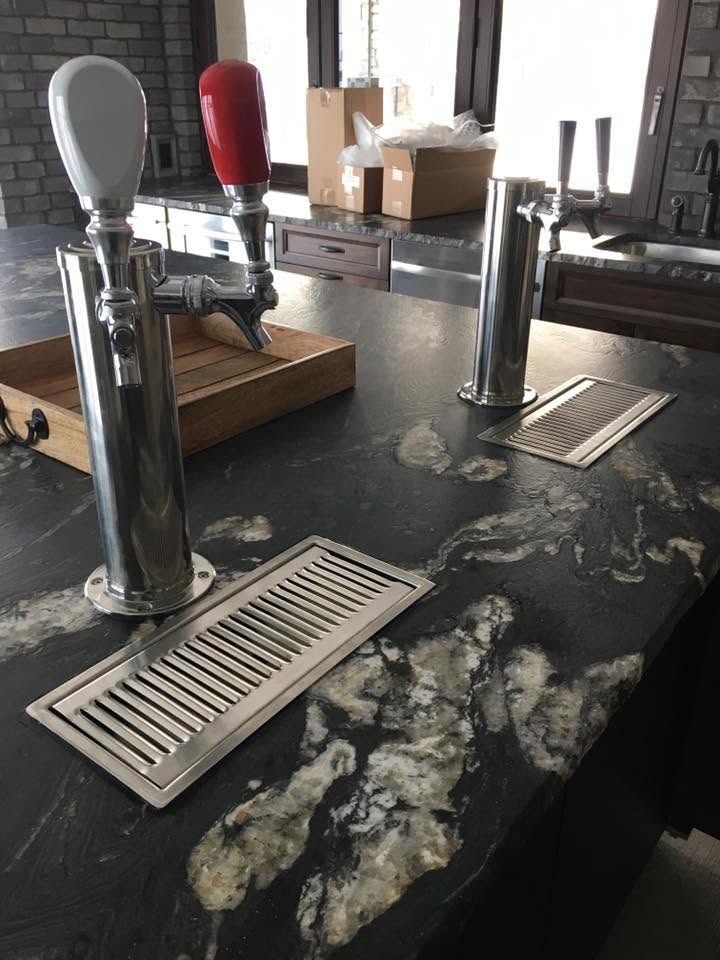 Home bar with two beer taps set into a marble countertop
